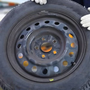 תיעוד של החלפת צמיגים בירושלים על ידי אדם שעוטה כפפות בצבע לבן